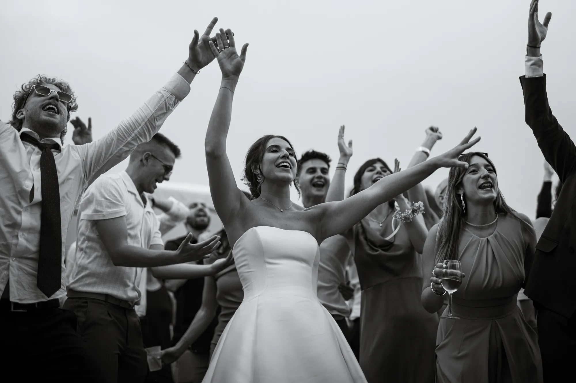 Sposa festeggiata dagli invitati, braccia alzate