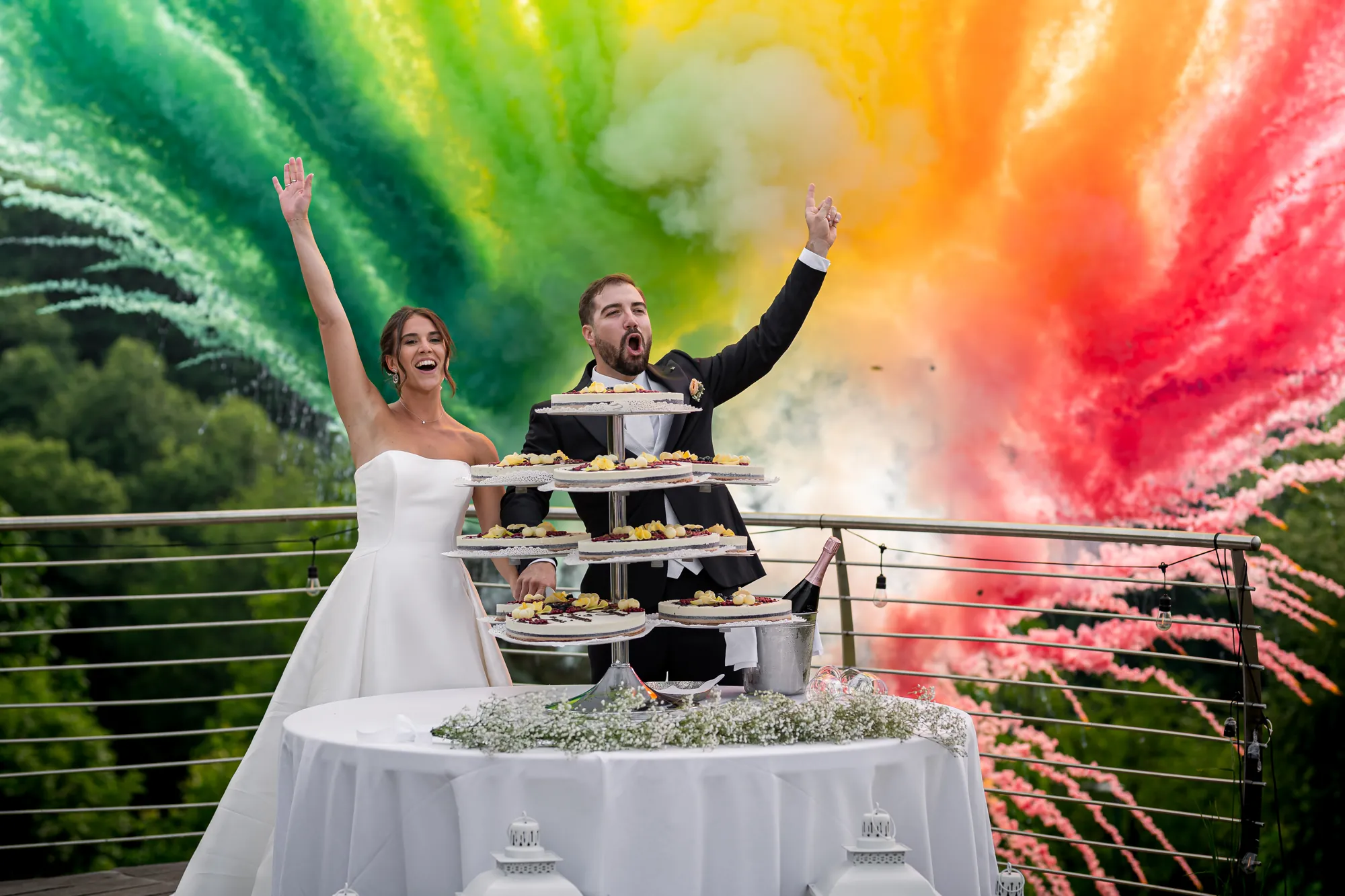 Sposi che festeggiano il taglio della torta con fumo colorato