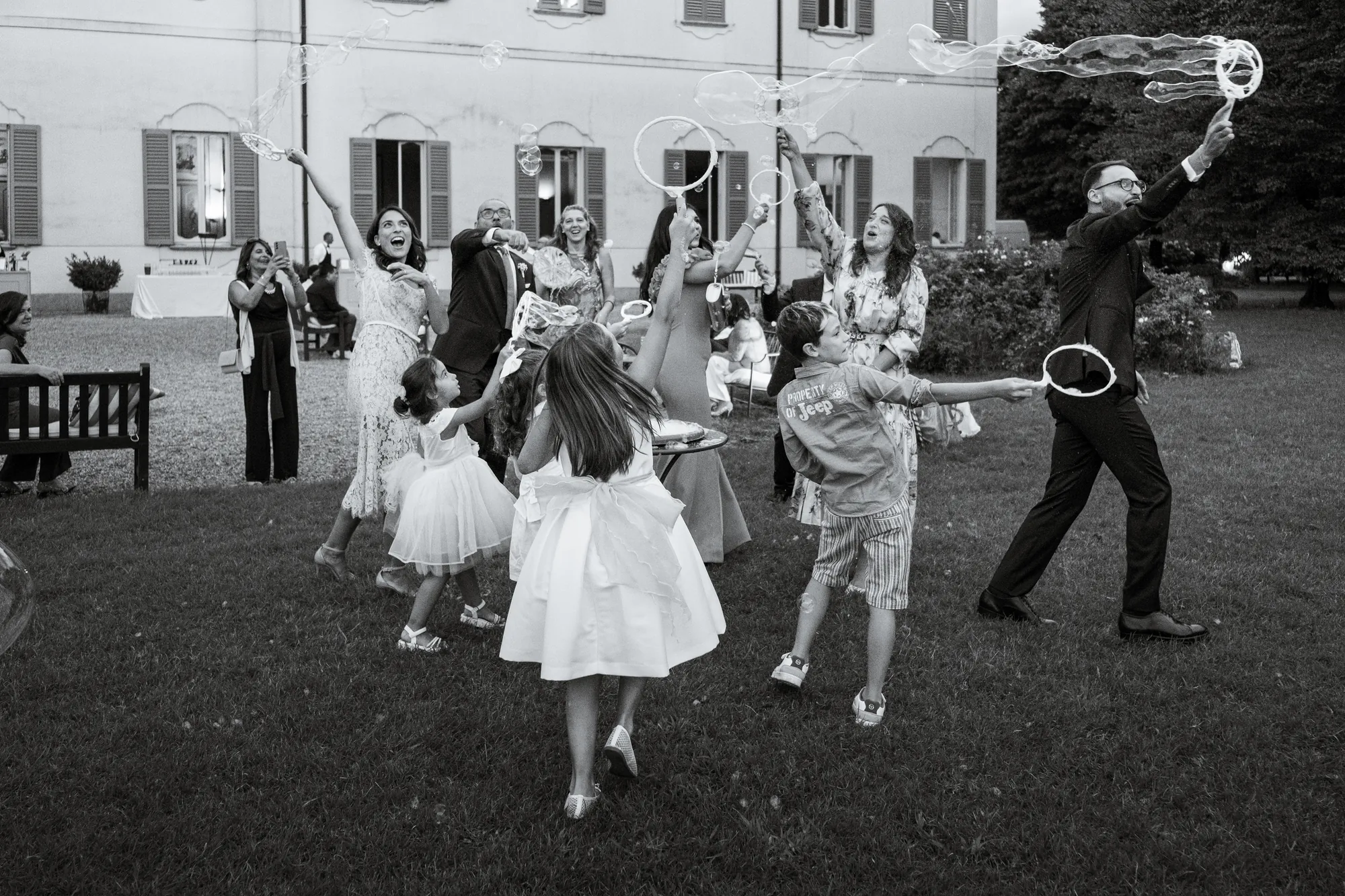 Invitati che giocano con le bolle nel giardino della villa