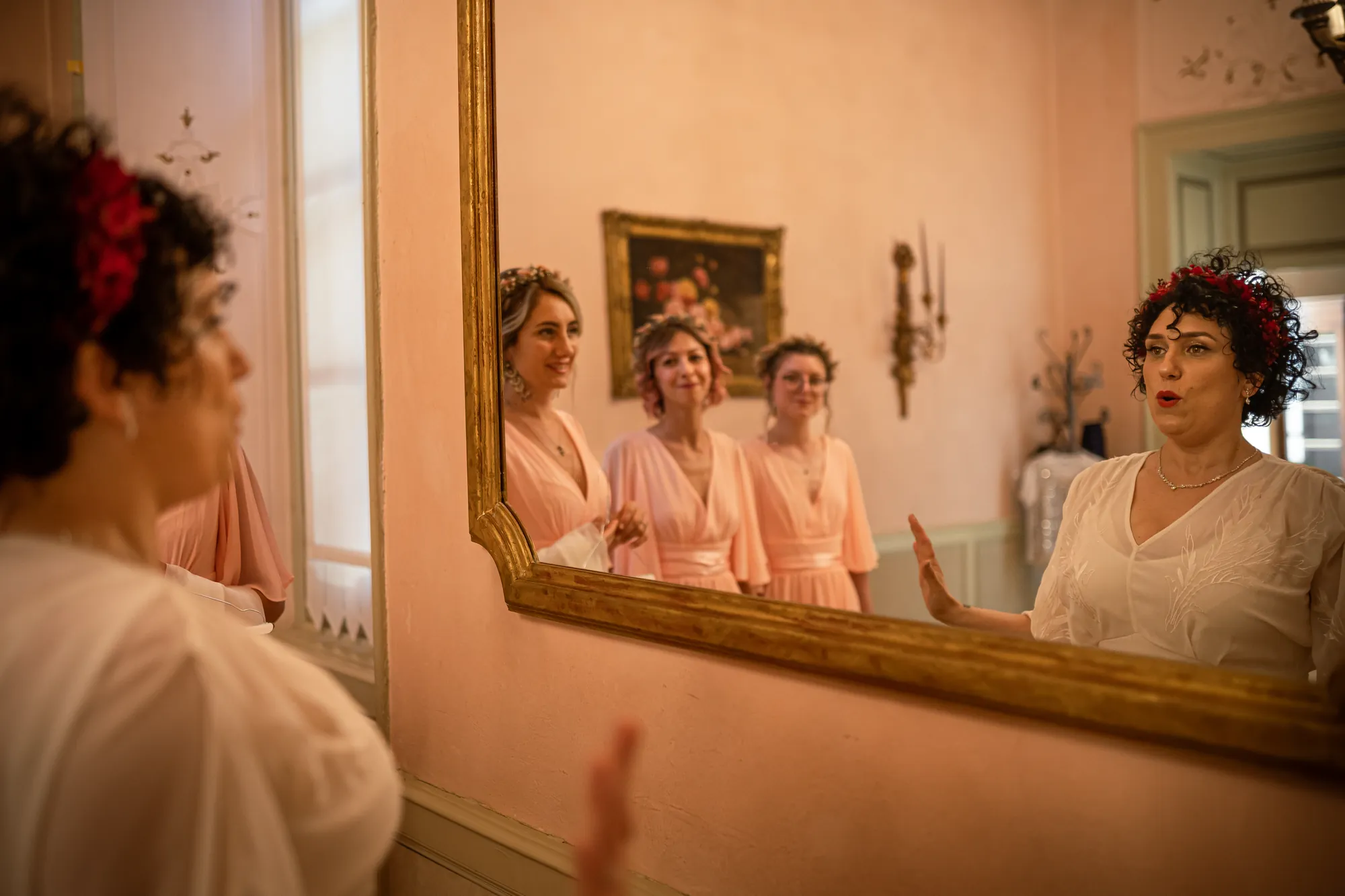 Sposa allo specchio con le damigelle durante i preparativi