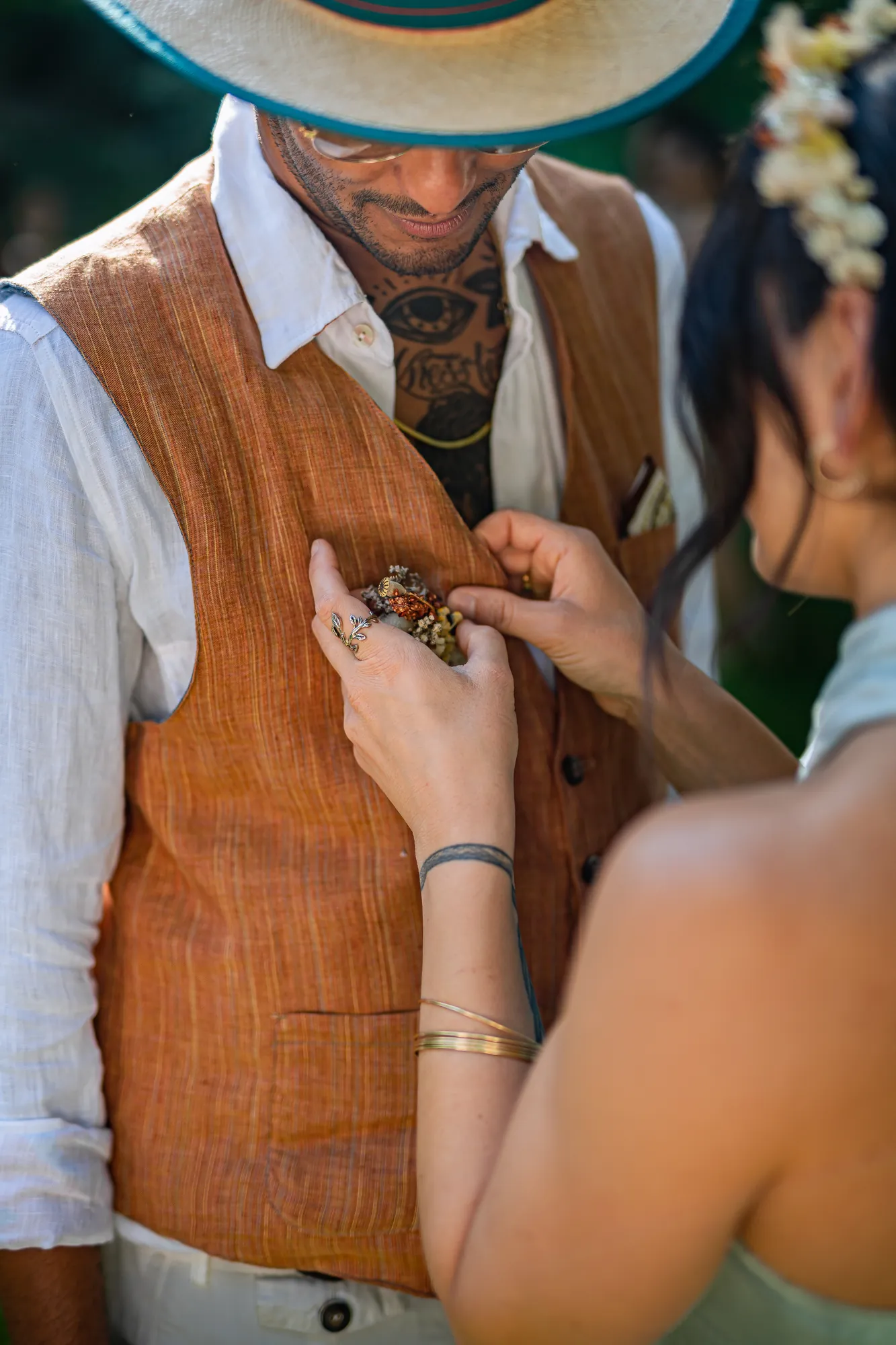 Lei sistema il boutonniere sullo sposo
